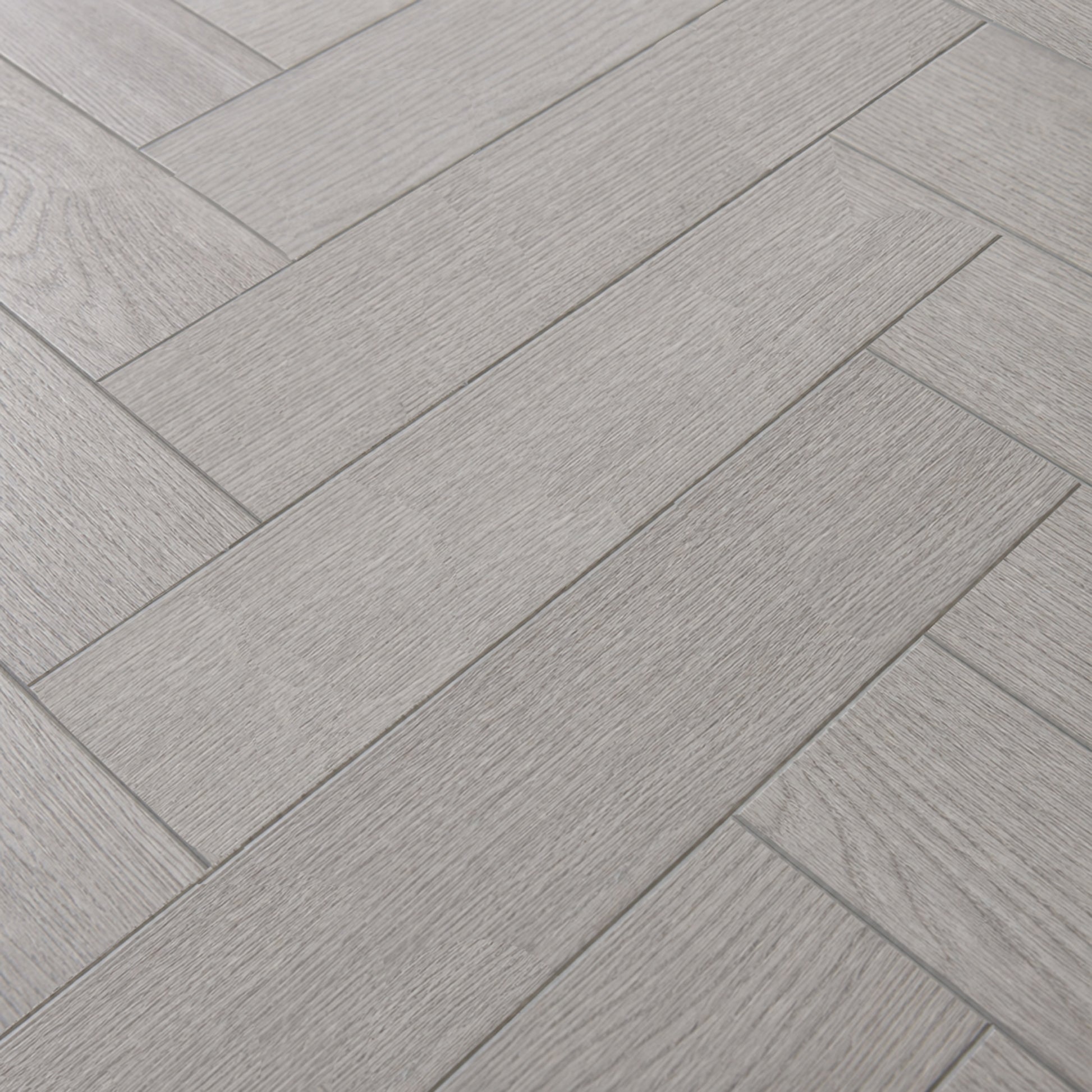 Close-up of the pattern and texture of Pyrenees Oak rigid LVT Herringbone flooring.