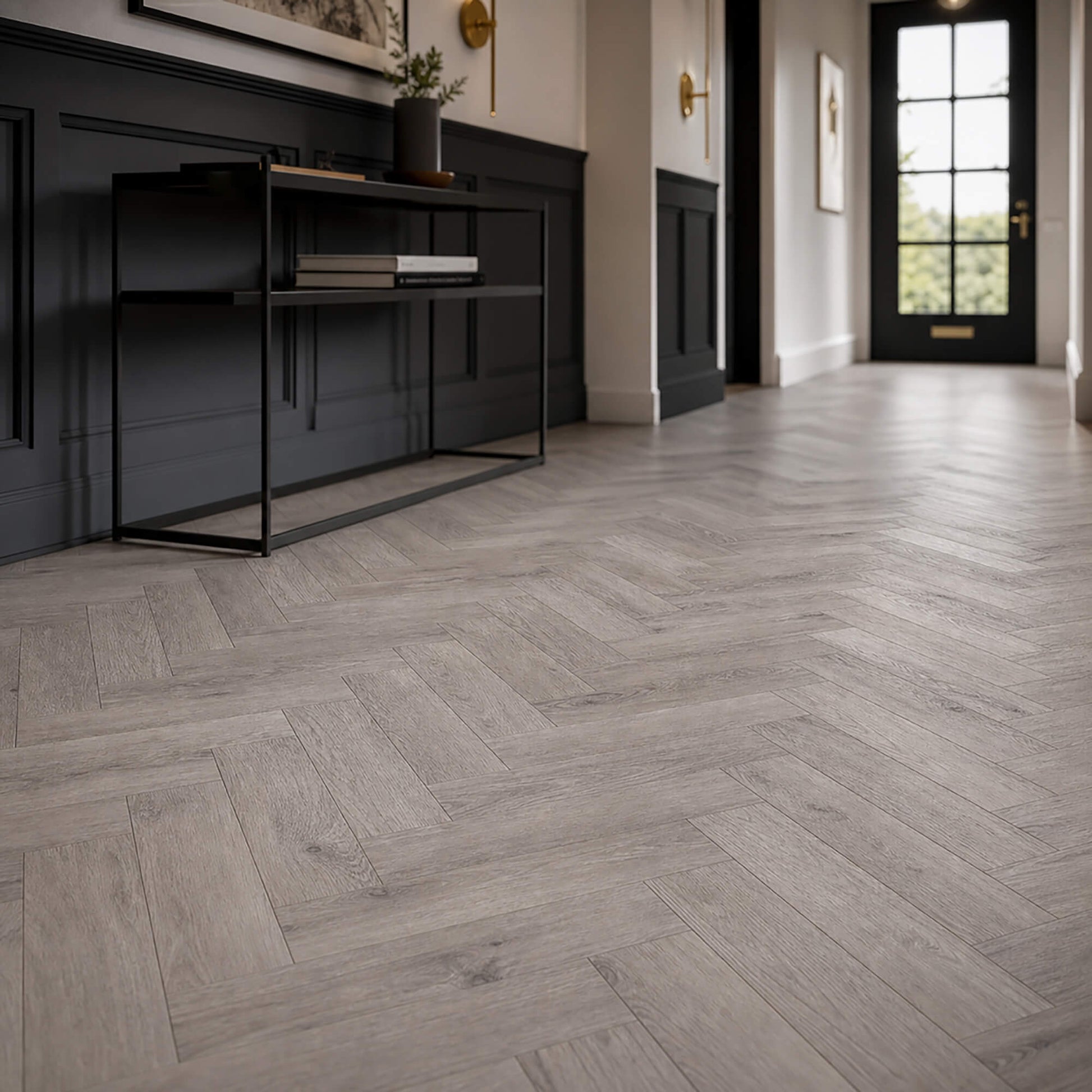 Castle Grey Herringbone laminate flooring in a modern interior hallway with black paneling, a black console table, and a black front door.
