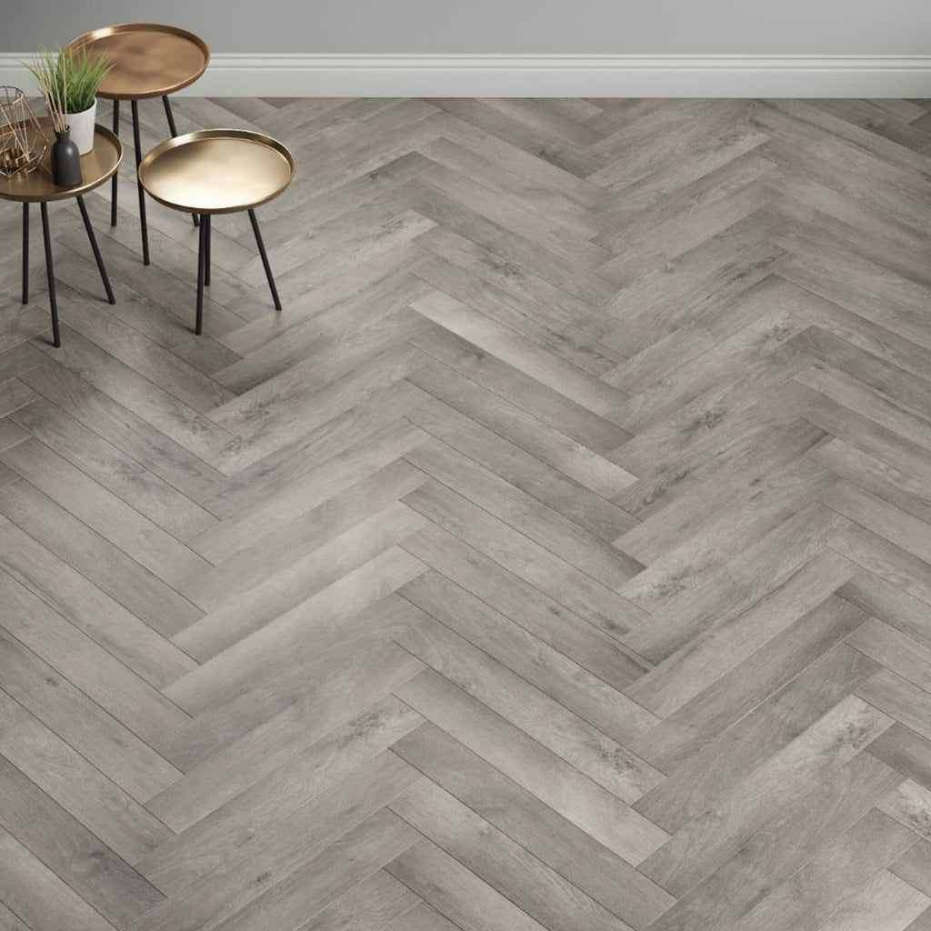 Castle Grey Herringbone Laminate Flooring accompanied by small round tables.