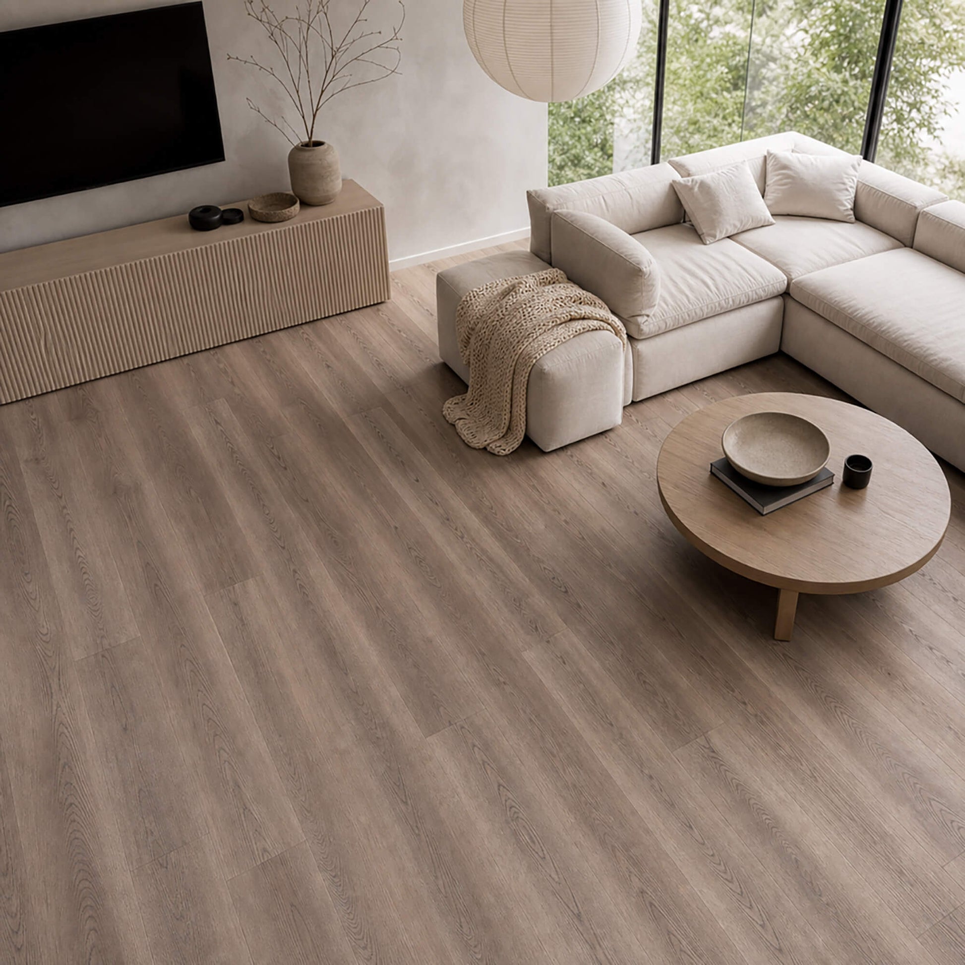 Modern living room with Dusky Oak Prestige Plus laminate flooring, beige sofa, and round coffee table.