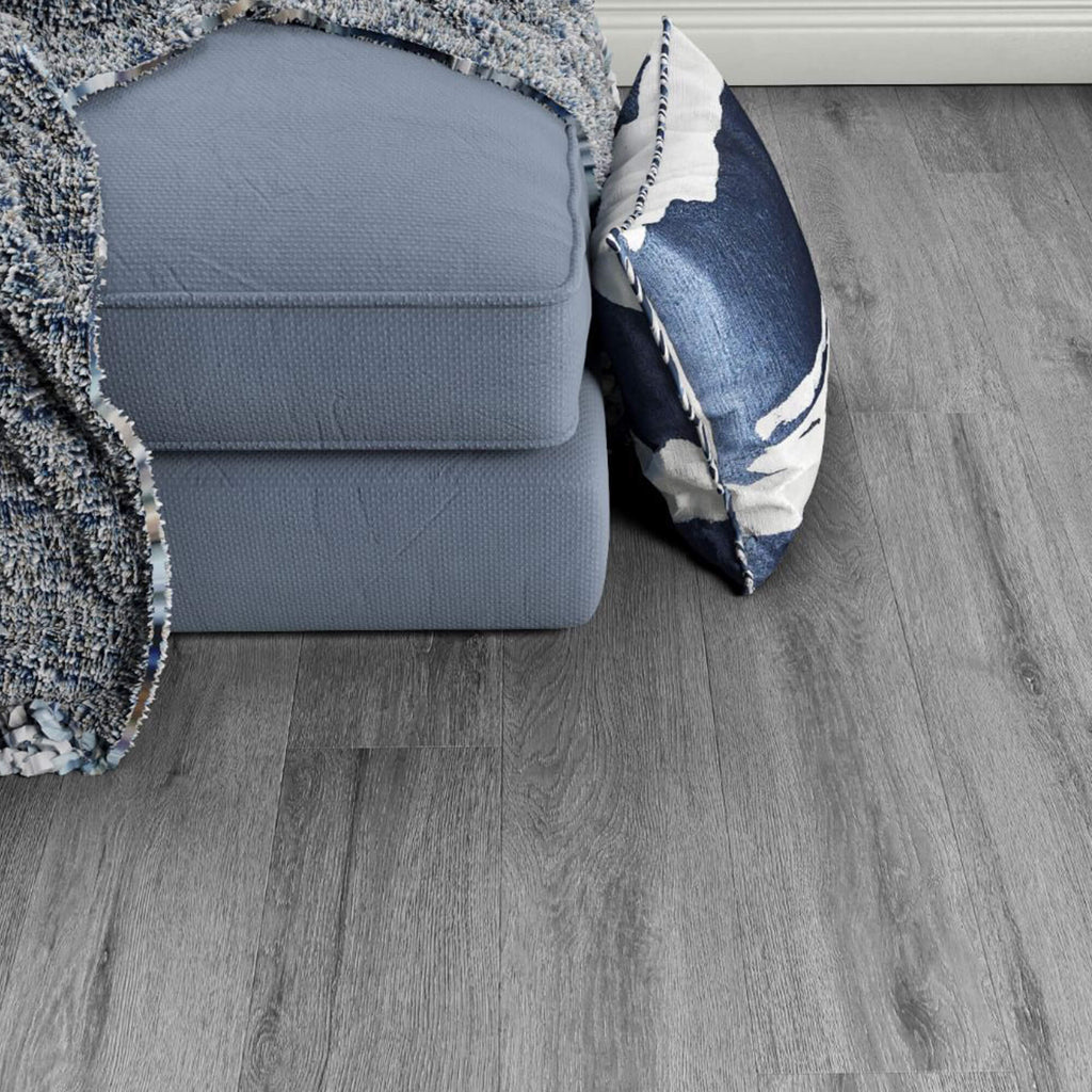 Harbour Oak Country Laminate Flooring with a sofa and a pillow in the background.