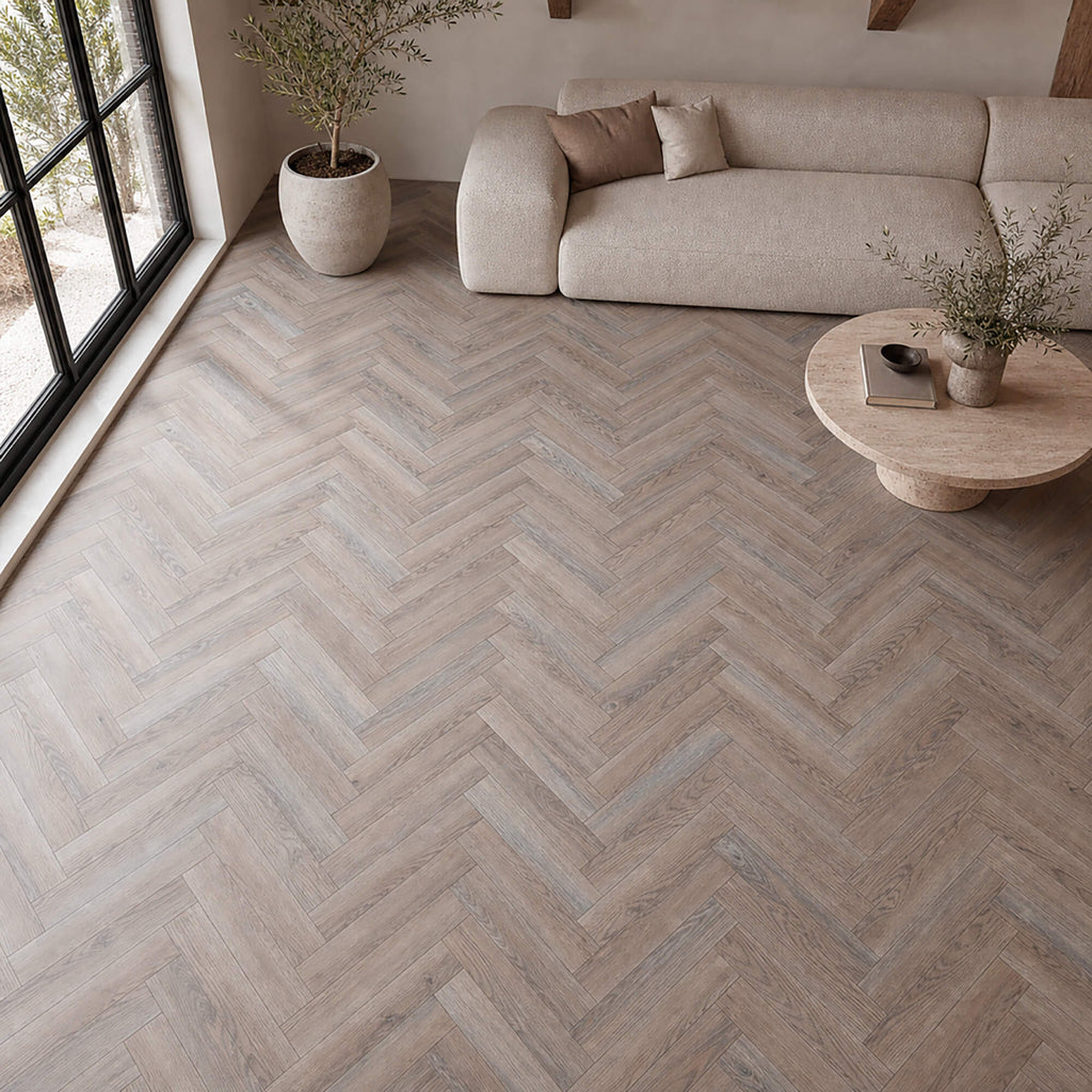 Manor Grey Oak Herringbone laminate flooring in a modern living room setting.