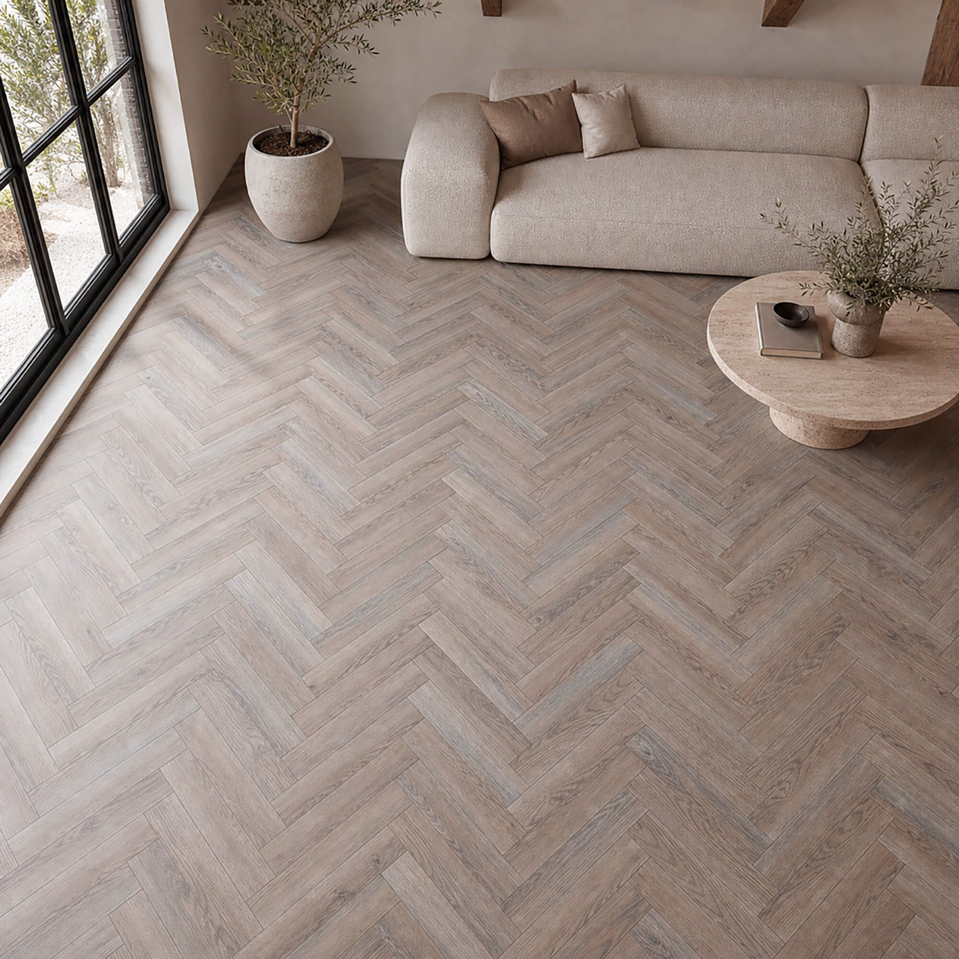 Manor Grey Oak Herringbone laminate flooring in a modern living room setting.