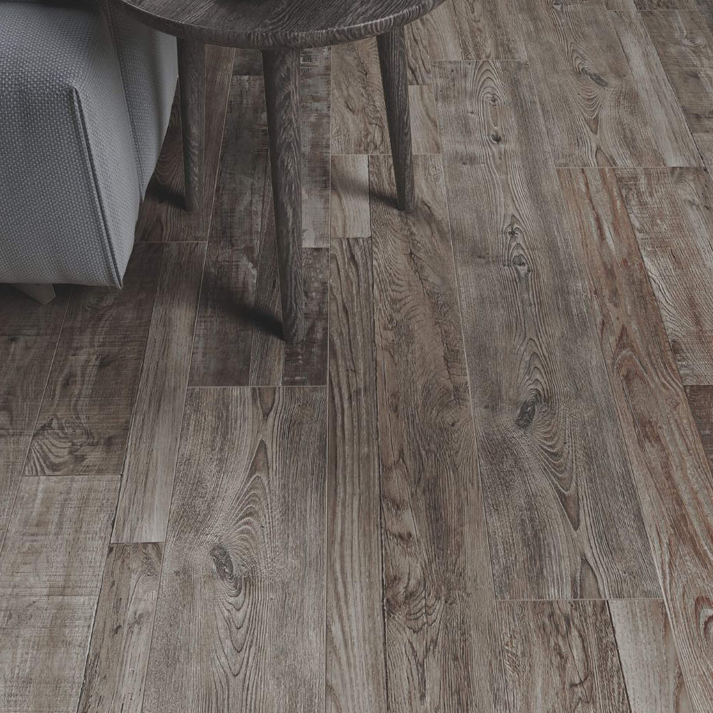 Reclaimed Oak Country Laminate Flooring with an edge of a sofa and table in the corner.