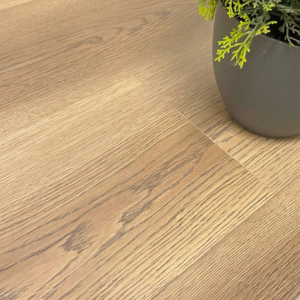 Close-up of Sable Oak Prestige Plus Laminate Flooring with a plant pot in the background.