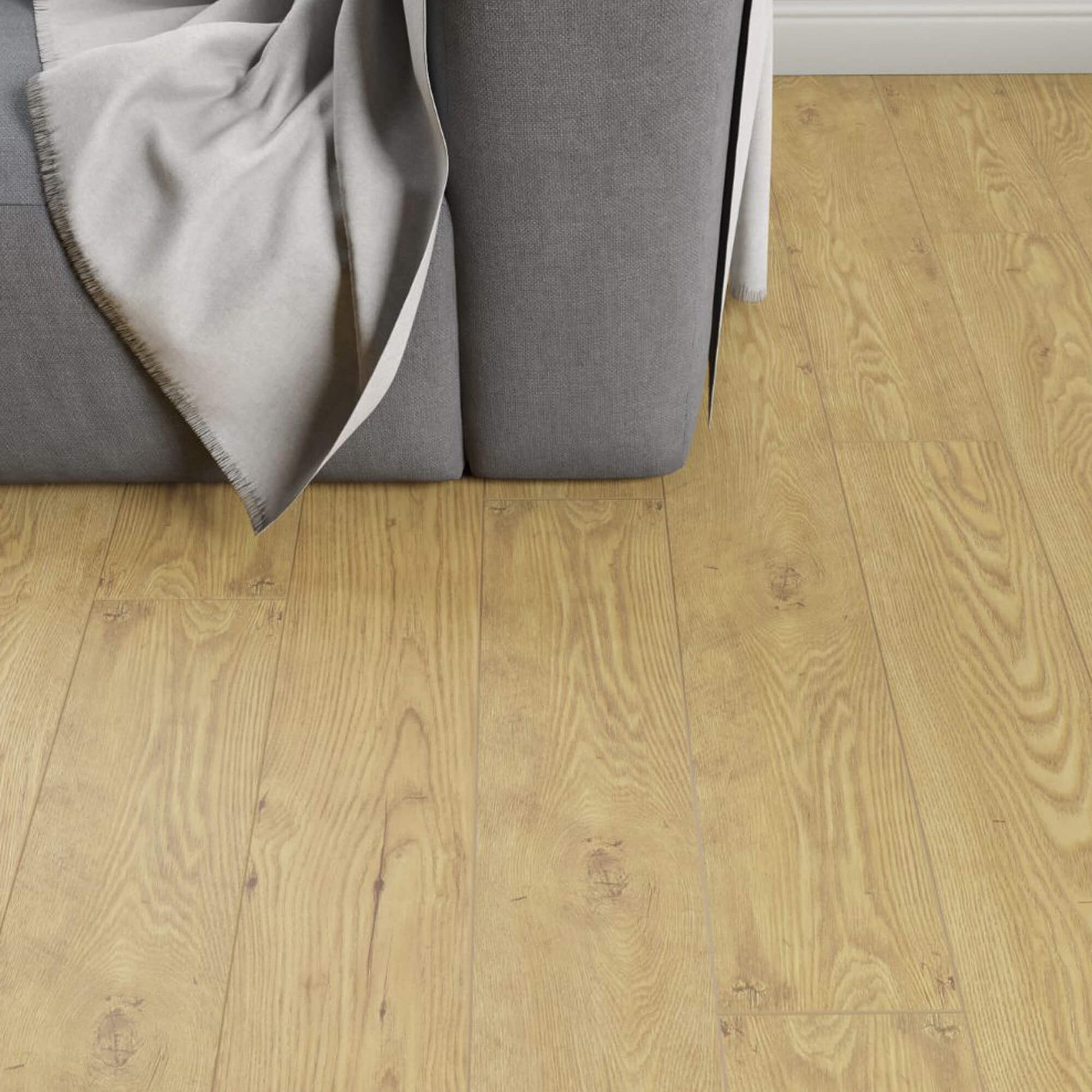 Tawny Chestnut Laminate Flooring in a living room setting with a sofa in the corner.