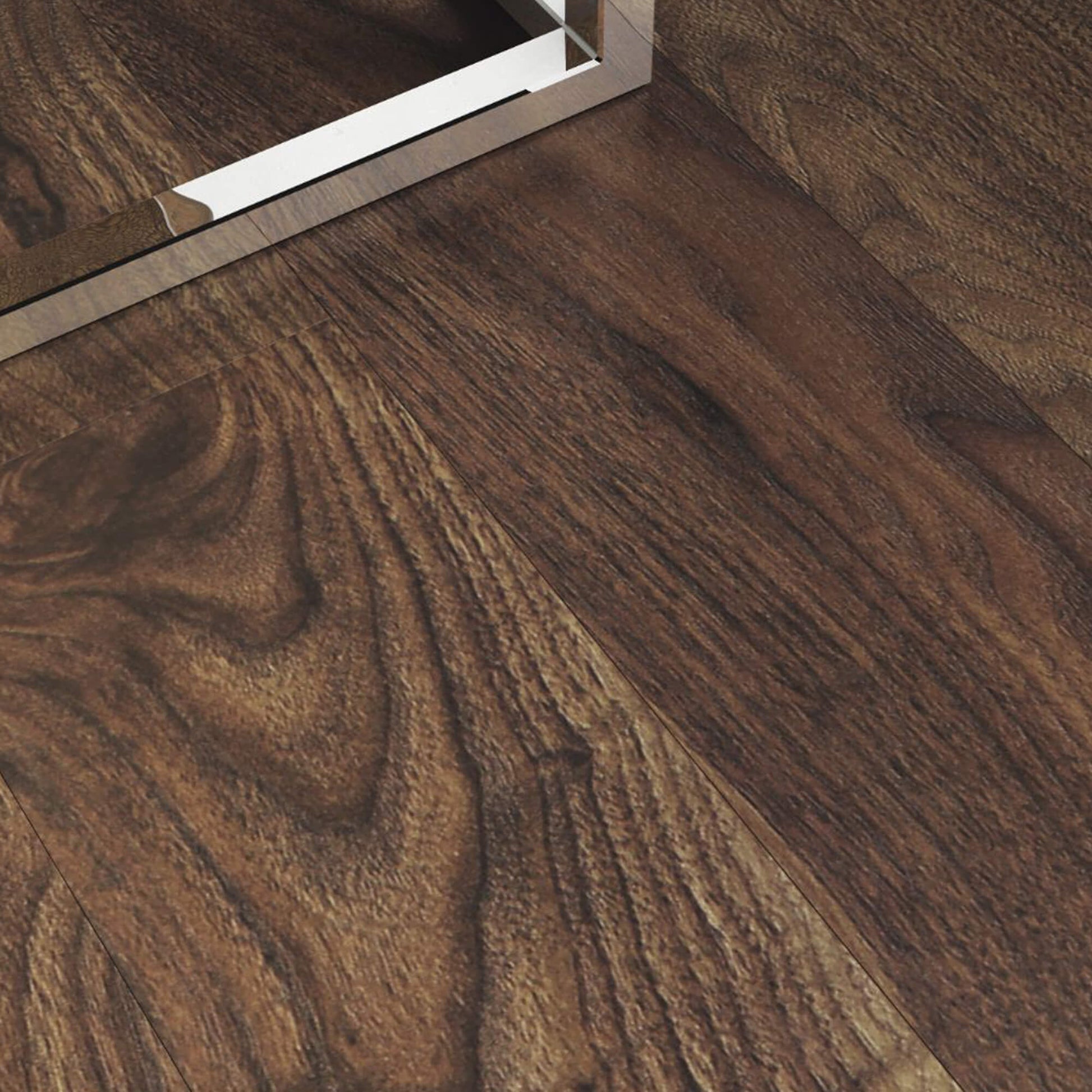 Close-up of a foot of a corner table sitting on Walnut Prestige Laminate Flooring.
