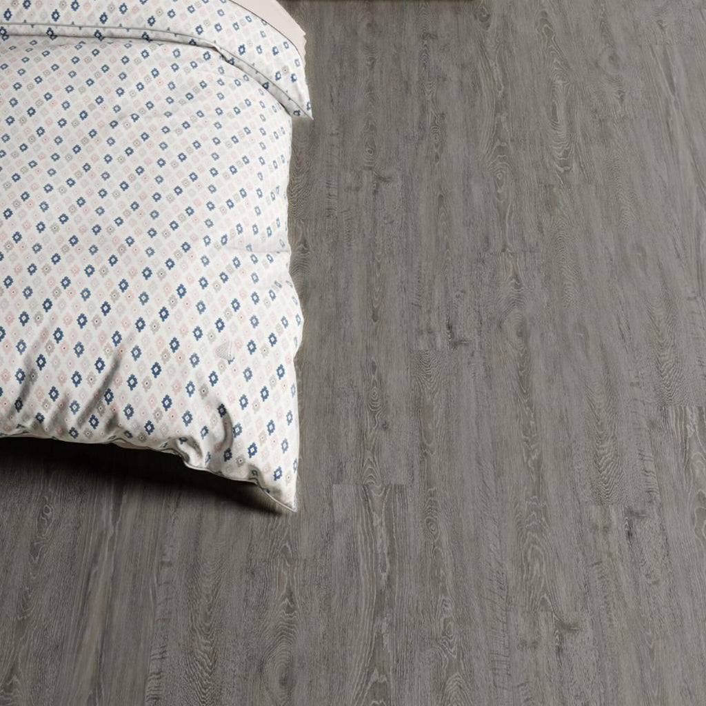 Patterned bedspread on Weathered Oak Rigid LVT flooring.